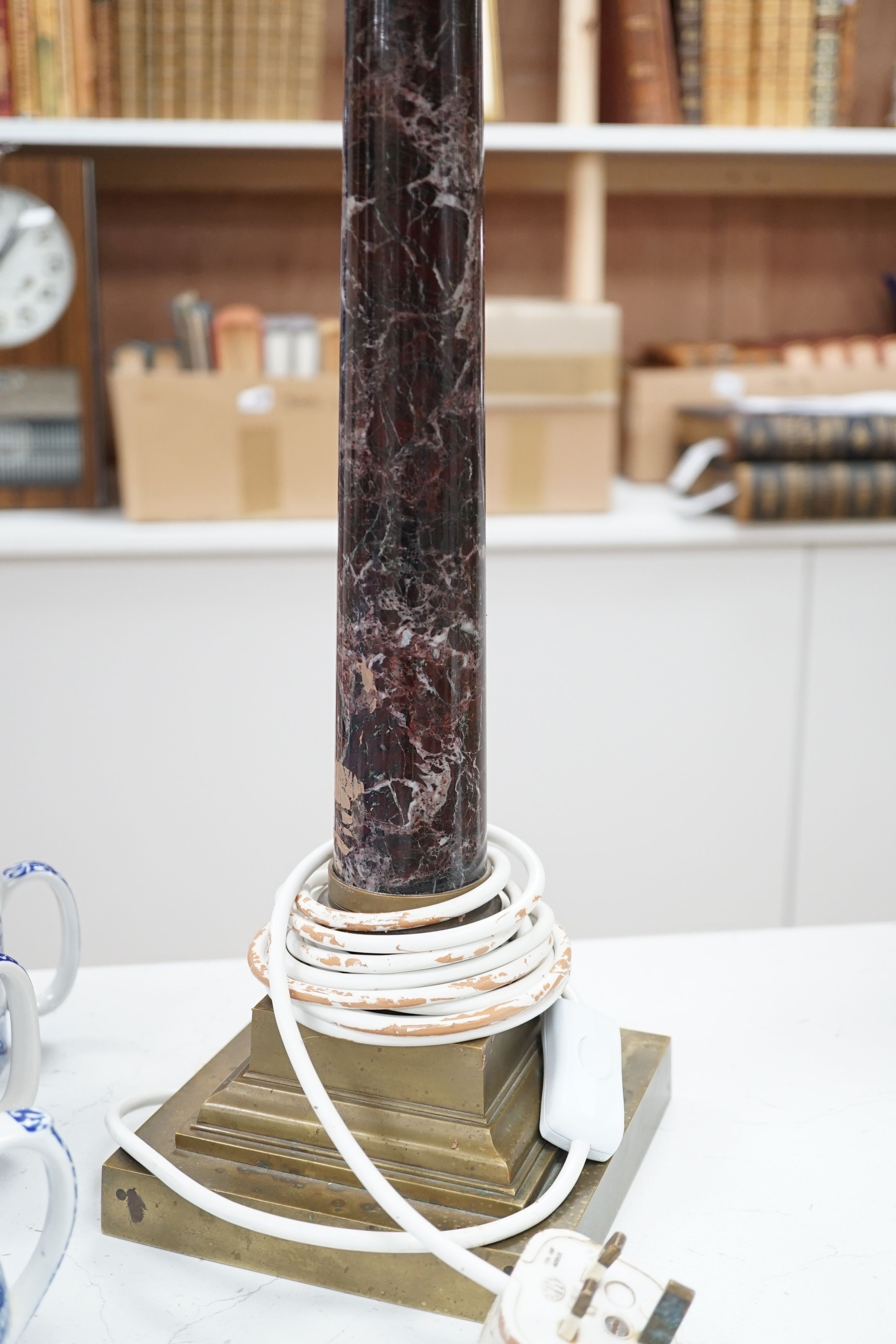 A brass and variegated marble Corinthian column lamp base, 47cms high, not including light fitting.